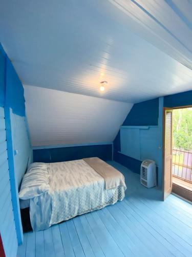 a blue bedroom with a bed and a window at Recanto da Magia in Palhoça