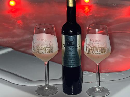 NašiceLa Luna Petite Suite Deluxe Apartment with Pool & Jacuzzi, Bikes and Covered Parking的一瓶葡萄酒,旁边放两杯酒