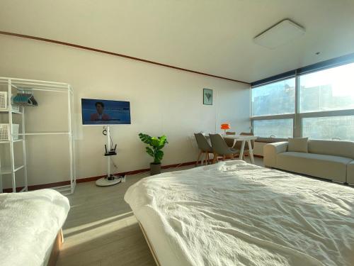 Un dormitorio con una cama, un sofá y una mesa. en 범계역2분 거리 퀸침대2개 무료주차가능 뚫린뷰가 일품, 