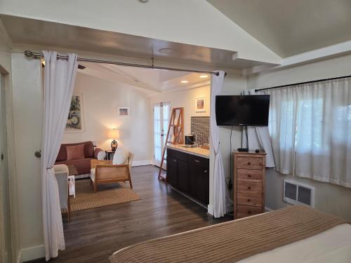 a bedroom with a bed and a tv in a room at Lamp Lighter Inn and Sunset Suites in Carmel