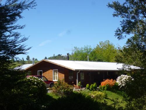 a house with a tin roof in a yard at Adela y Helmut in Cunco