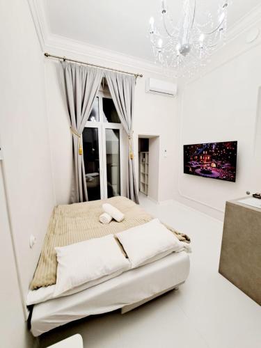 a white bedroom with a bed and a window at Poznaj Mickiewicza 4 in Racibórz