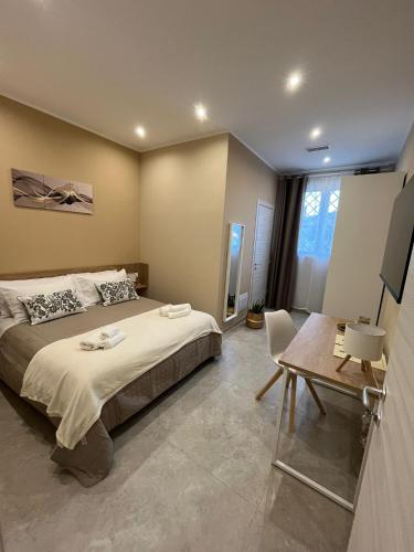 a bedroom with a bed and a table and a desk at G&Ghomeciampinosuite in Ciampino