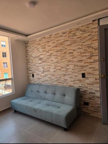 kanapa w pokoju z ceglaną ścianą w obiekcie Hermoso y acogedor apartamento en conjunto cerrado w mieście Ibagué