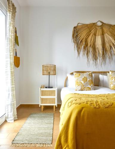 a bedroom with a bed and a table with a lamp at Yeotown Madeira Wellness Hotel and Nature Stay in Arco da Calheta