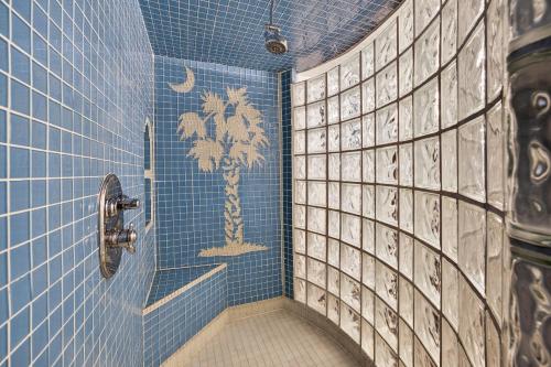 Un baño con azulejos azules y una palmera pintada en la pared. en PW1310: 1310 Pelican Watch, en Seabrook Island