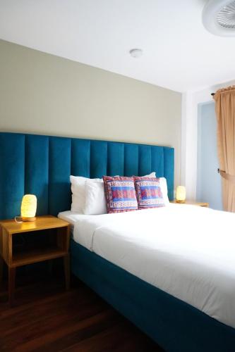 a bedroom with a large bed with a blue headboard at ONDA Boquete - En Desarrollo in Boquete