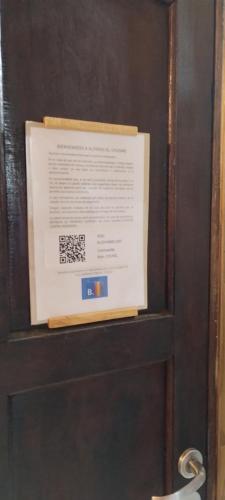 een bord op een houten deur met een bord erop bij Alpinas El Chusmo 2 in Villa Ciudad Parque