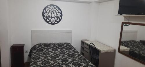 a small bedroom with a bed and a mirror at Recanto da Lagoa in Passo de Torres