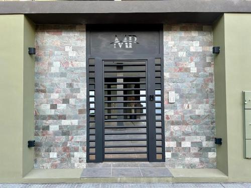 a black door on the side of a brick building at MorenoPLAZA in Concepción del Uruguay