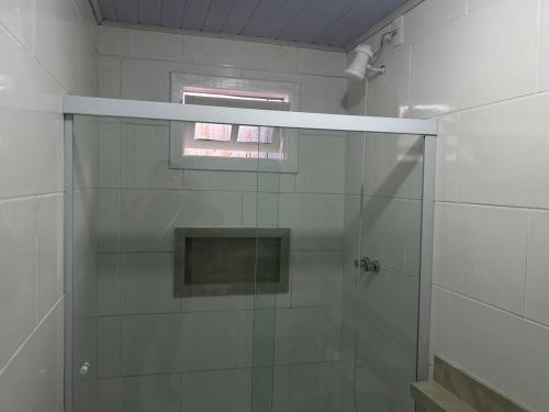 a shower with a glass door in a bathroom at Casa Átrio em Biguaçu próximo às Praias in Biguaçu