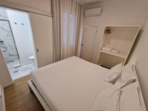 a small bedroom with a white bed and a window at Market Downtown T3 in Funchal