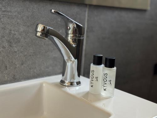 a bathroom sink with two bottles ofodorizers on it at majestic tiny home with private pool in Trikomo
