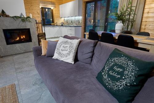 ein Wohnzimmer mit einem lila Sofa mit Kissen darauf in der Unterkunft Na Las Czas, Wilga in Wilga