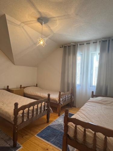 a bedroom with three beds and a ceiling at Mountain villa in Gorna Belica - Villa Hani in Struga