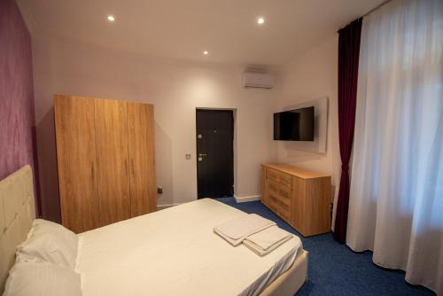 ein Hotelzimmer mit einem Bett und einem Fernseher in der Unterkunft Vibe Studio Centrul Vechi Craiova in Craiova