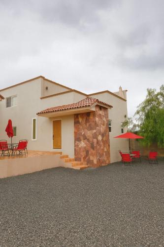 ein weißes Haus mit roten Stühlen und einer Terrasse in der Unterkunft Hotel Flamora in Francisco Zarco