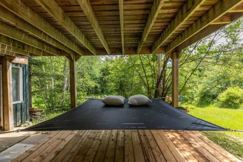 Una estera en un patio con dos almohadas encima. en Lake Views, Hot Tub, Fireplace and Pool Table, en Chertsey