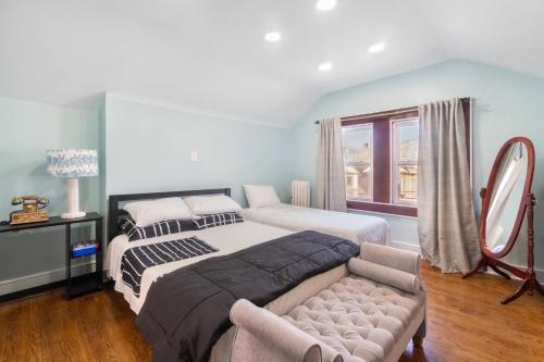 una camera da letto con due letti, un divano e una finestra di The City Climb a Guttenberg