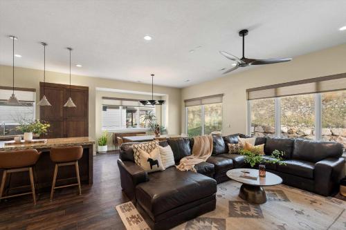 ein Wohnzimmer mit einem Ledersofa und einer Küche in der Unterkunft Trappers Ridge Home Stunning Mountain Views and Family Fun in Wolf Creek Village