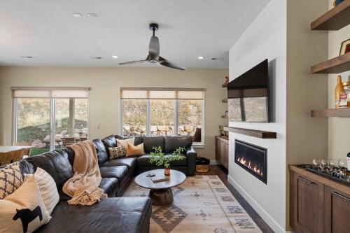 ein Wohnzimmer mit einem Ledersofa und einem Kamin in der Unterkunft Trappers Ridge Home Stunning Mountain Views and Family Fun in Wolf Creek Village