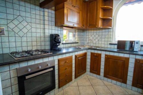 伊斯基亚Casa Don Peppino City Center的配有木制橱柜和炉灶烤箱的厨房