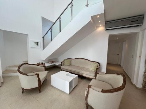 a living room with two chairs and a staircase at Condo cozy 1bdr 1bth in Punta Cana