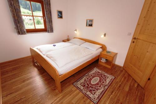 a bedroom with a bed and a window and a door at Ferienwohnungen Auhaus in Martello