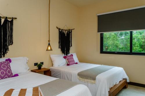 una camera da letto con due letti e una finestra di New! Gorgeous Tulum luxury villa with 2 pools a Tulum