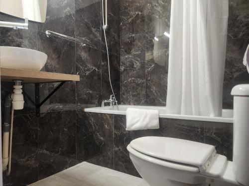 ein Badezimmer mit Toilette und Waschbecken in der Unterkunft Hôtel et Restaurant Les2M in Fontenay-le-Comte