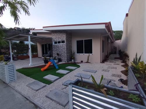 Un patio con zona de juegos delante de una casa en JJ Lux Residential, en Jacó