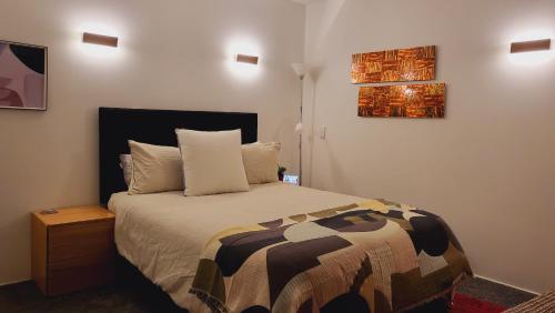 a bedroom with a bed and a painting on the wall at Stylish Home within Central Wellington - Free Parking in Wellington