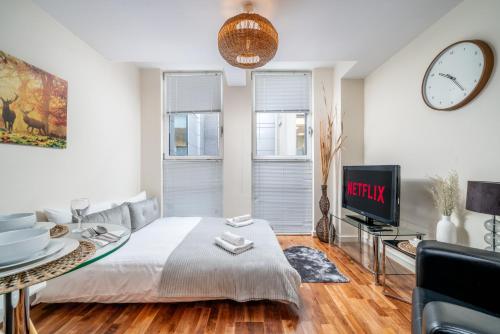 a living room with a bed and a tv at London Central 1 bed deluxe-Moorgate in London