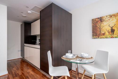 a dining room with a table and white chairs at London Central 1 bed deluxe-Moorgate in London