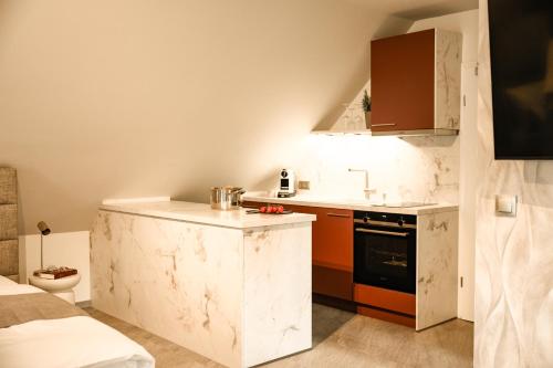 a small kitchen with white marble counters and a stove at Spalter EINSER - Luxury Apartments & Ferienwohnungen in Spalt