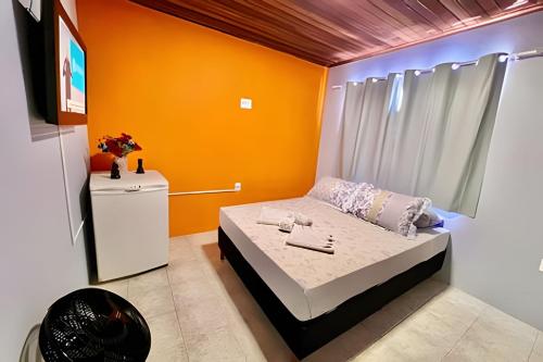 a bedroom with a bed with an orange wall at #MaReSiaSdaPaz próximo ao centro de Matinhos in Matinhos