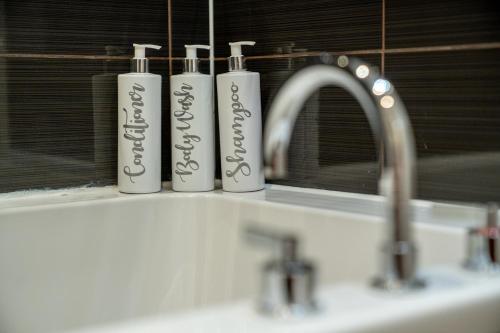 three bottles ofodorizers sitting on a bathroom sink at London Central 1 bed deluxe-Moorgate in London