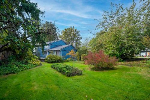 a blue house in a yard with green grass at Richmond 6011 in Richmond