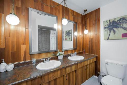 a bathroom with two sinks and a mirror and a toilet at Richmond 6011 in Richmond