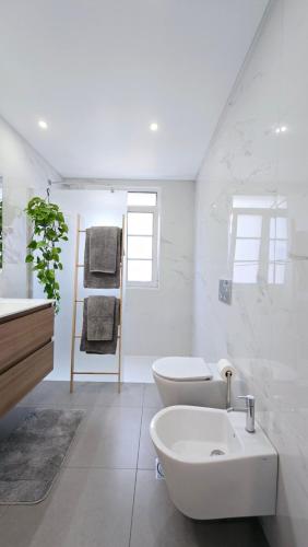 a white bathroom with a sink and a toilet at In City - Funchal Heart with Rooftop in Funchal