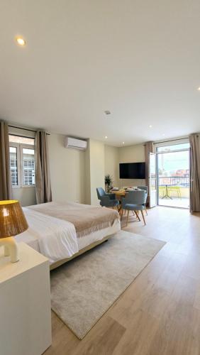a bedroom with a large bed and a living room at In City - Funchal Heart with Rooftop in Funchal