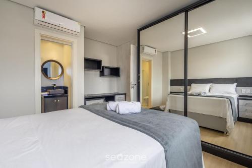 a bedroom with two beds and a mirror at Sua estadia completa a poucos minutos do mar em BC – STLs in Balneário Camboriú