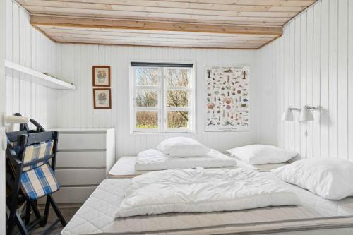 Classic Holiday Home Near Beach And Nature في Grenå Strand: سريرين في غرفة بيضاء مع نافذة