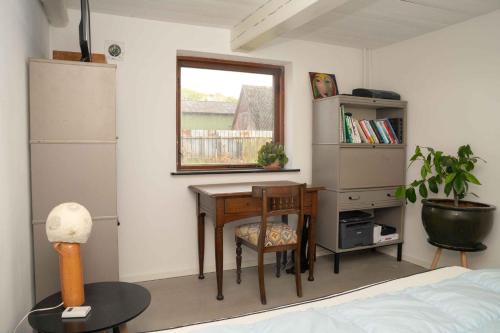 a bedroom with a desk and a table and a window at Renovated Country Home 50 M From The Sea in Blans