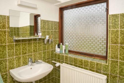 a green tiled bathroom with a sink and a window at Renovated Country Home 50 M From The Sea in Blans