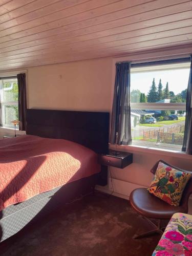a bedroom with a bed and a window and a chair at Holiday Oasis With Terrace And Sloping Garden in Tikøb