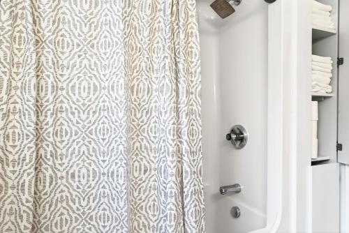 a shower with a shower curtain in a bathroom at Cozy 3BR Downtown Fredericton Home with Parking in Fredericton