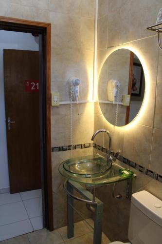 ein Badezimmer mit einem Glaswaschbecken und einem Spiegel in der Unterkunft Aparthotel Maison Suisse in Asunción