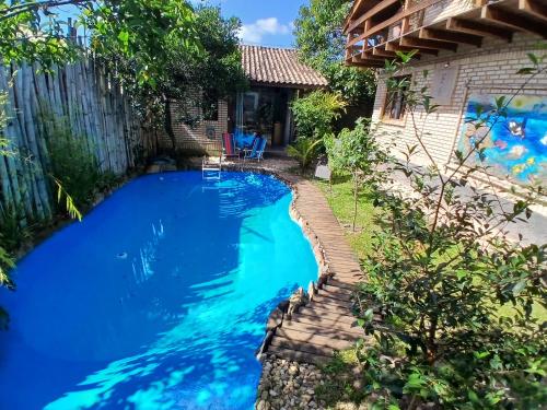 a swimming pool in a backyard with blue water at Casa Sol & Lua in Florianópolis