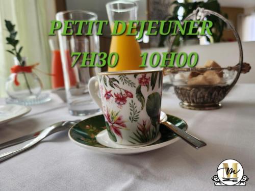 una taza de té y un plato en una mesa en Hôtel et Restaurant Les2M, en Fontenay-le-Comte